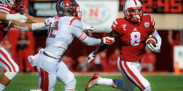 LINCOLN, NE - OCTOBER 25: Running back Ameer Abdullah #8 of the Nebraska Cornhuskers runs past defensive back Nadir Barnwell #12 of the Rutgers Scarlet Knights during their game at Memorial Stadium on October 25, 2014 in Lincoln, Nebraska. (Photo by Eric Francis/Getty Images)
