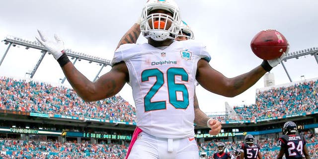 MIAMI GARDENS, FL - OCTOBER 25: Lamar Miller #26 of the Miami Dolphins celebrates his touchdown in the second quarter against the Houston Texans at Sun Life Stadium on October 25, 2015 in Miami Gardens, Florida. (Photo by Chris Trotman/Getty Images)