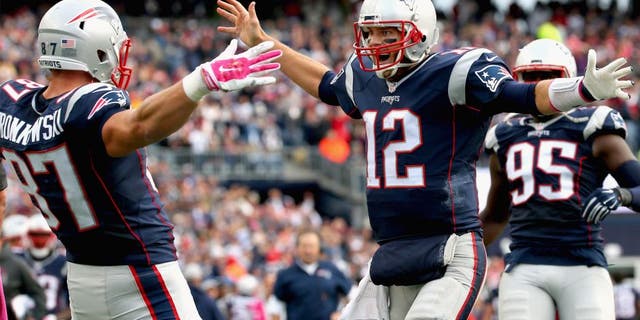 Tom Brady #12 and Rob Gronkowski #87 of the New England Patriots react after Gronkowski scored a touchdown during the fourth quarter against the New York Jets at Gillette Stadium on October 25, 2015 in Foxboro, Massachusetts. (Photo by Jim Rogash/Getty Images)