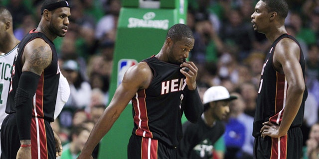 Oct. 26: Miami Heat forward LeBron James, left, talks with teammates Dwyane Wade, center, and Chris Bosh, right, while trailing the Boston Celtics during the first half of an NBA basketball game in Boston.