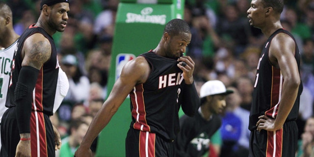 Oct. 26: Miami Heat forward LeBron James, left, talks with teammates Dwyane Wade, center, and Chris Bosh, right, while trailing the Boston Celtics during the first half of an NBA basketball game in Boston.