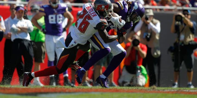 Oct 26, 2014; Tampa, FL, USA; Minnesota Vikings wide receiver Cordarrelle Patterson (84) runs with the ball as Tampa Bay Buccaneers cornerback Crezdon Butler (26) defends during the first half at Raymond James Stadium. Mandatory Credit: Kim Klement-USA TODAY Sports