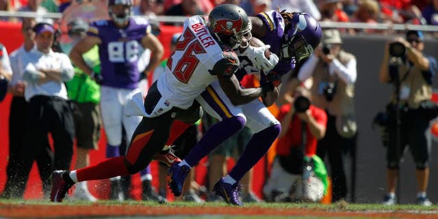 Oct 26, 2014; Tampa, FL, USA; Minnesota Vikings wide receiver Cordarrelle Patterson (84) runs with the ball as Tampa Bay Buccaneers cornerback Crezdon Butler (26) defends during the first half at Raymond James Stadium. Mandatory Credit: Kim Klement-USA TODAY Sports