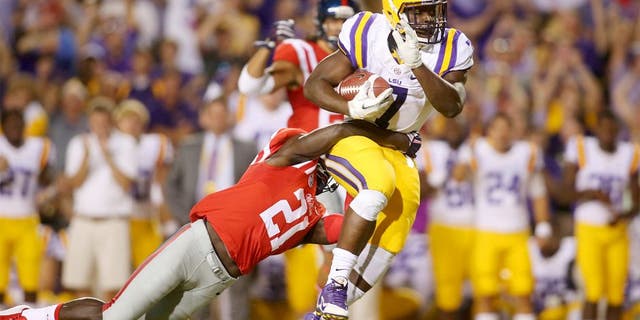 Oct 25, 2014; Baton Rouge, LA, USA; LSU Tigers running back Leonard Fournette (7) is tackled by Mississippi Rebels defensive back Senquez Golson (21) as he carries the ball in the first quarter at Tiger Stadium. Mandatory Credit: Crystal LoGiudice-USA TODAY Sports