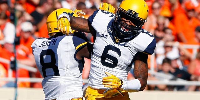 Oct 25, 2014; Stillwater, OK, USA; West Virginia Mountaineers safety Dravon Henry (6) and safety Karl Joseph (8) celebrate after Dravon Henry intercepted an Oklahoma State Cowboy pass during the first quarter at Boone Pickens Stadium. Mandatory Credit: Alonzo Adams-USA TODAY Sports