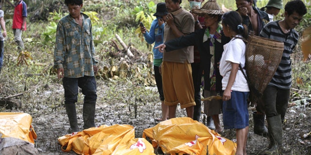 Oct. 29: Survivors look at the body of their family member who died in a tsunami at Munte, Indonesia. he toll from Monday's tsunami rose to more than 400 on Friday as officials found more bodies, and about 300 people were still missing, according to a provincial disaster management center official.