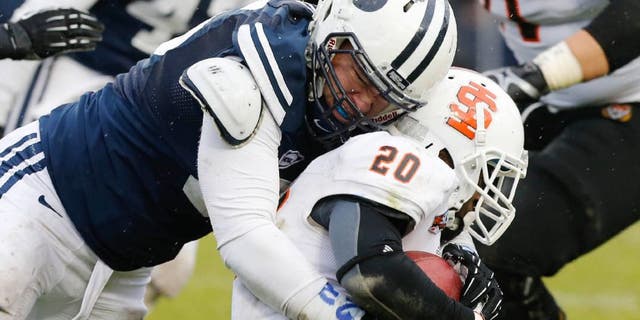 Nov 16, 2013; Provo, UT, USA; Idaho State Bengals running back Aaron Prier (20) is tackled by Brigham Young Cougars defensive lineman Logan Taele (95) during the third quarter at Lavell Edwards Stadium. BYU won 59-13. Mandatory Credit: Chris Nicoll-USA TODAY Sports.