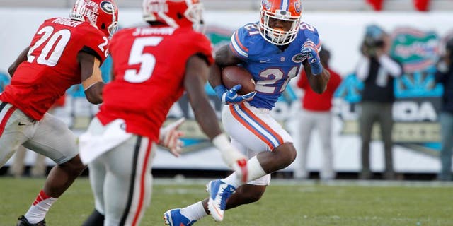 Nov 1, 2014; Jacksonville, FL, USA; Florida Gators running back Kelvin Taylor (21) runs with the ball against the Georgia Bulldogs during the second half at EverBank Field. Florida Gators defeated the Georgia Bulldogs 38-20. Mandatory Credit: Kim Klement-USA TODAY Sports