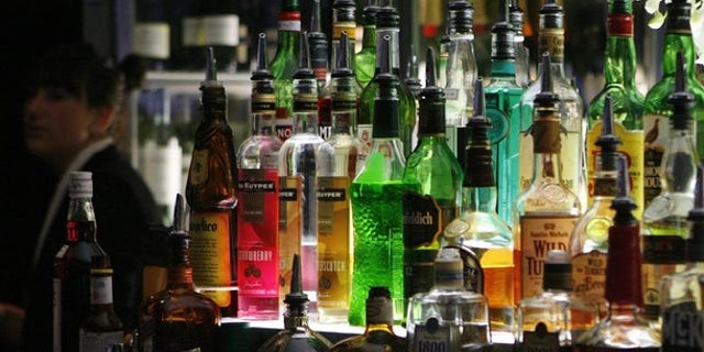 A bartender walks next to liquor bottles in a bar in central Sydney May 11, 2009. The Australian government will announce on May 12 what is the most keenly watched national budget in years, as the country heads for a recession, unemployment rises and rumours swirl of a possible early general election. The government is expected to increase taxes for cigarettes and alcohol in this budget. REUTERS/Daniel Munoz (AUSTRALIA POLITICS BUSINESS IMAGES OF THE DAY)