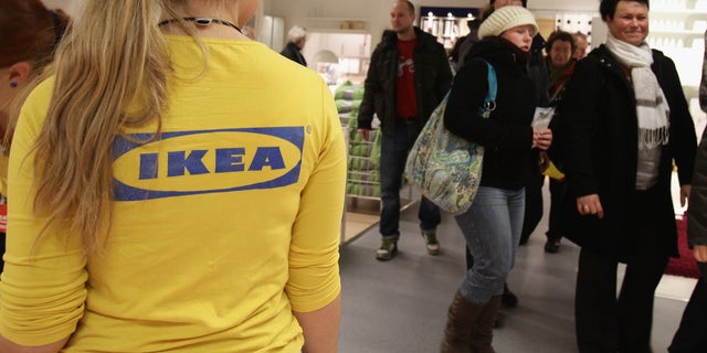 BERLIN, GERMANY - DECEMBER 13:  An Ikea employee watches customers shopping during a store opening at the 4th Ikea chain store in Berlin Lichtenberg on December 13, 2010 in Berlin, Germany. Ikea, a Swedish furniture and household goods company now has 46th chain stores in Germany, including the newly opened one in Berlin Lichtenberg, which is the biggest one in Germany.  (Photo by Andreas Rentz/Getty Images)