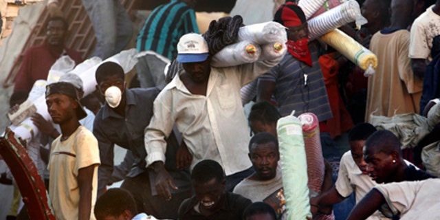 Jan. 16: People take goods from a collapsed store in Port-au-Prince.