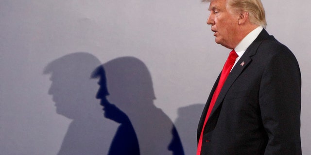 U.S. President Donald Trump casts shadows on the wall as he walks with Poland's President Andrzej Duda at the end of a joint press conference, in Warsaw, Poland, Thursday, July 6, 2017.(AP Photo/Czarek Sokolowski)
