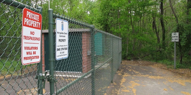 No trespassing and no dumping signs are posted in a neighborhood at the edge of a wooded area where the remains of seven people have been found since 2007 in Newington, Conn., Tuesday, May 12, 2015, Police believe a man serving prison time in Connecticut for manslaughter murdered all the victims, whose bodies were found in the woods just over the town line in New Britain, Conn. (AP Photo/Dave Collins)