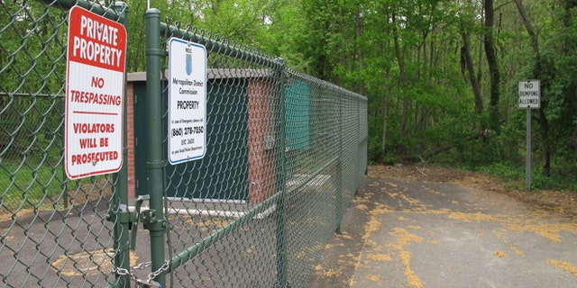 No trespassing and no dumping signs are posted in a neighborhood at the edge of a wooded area where the remains of seven people have been found since 2007 in Newington, Conn., Tuesday, May 12, 2015, Police believe a man serving prison time in Connecticut for manslaughter murdered all the victims, whose bodies were found in the woods just over the town line in New Britain, Conn. (AP Photo/Dave Collins)