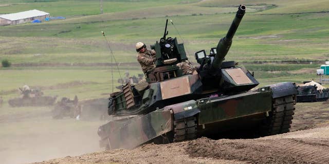 U.S. M1A2 Abrams tank moves to firing positions during joint military exercises at the Vaziani military base outside Tbilisi, Georgia, Wednesday, May 18, 2016. About 1,300 U.S., British and Georgian troops conducted joint exercises aimed at training the former Soviet republic's military for participation in the NATO Response Force. (AP Photo/Shakh Aivazov)