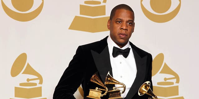 Jay-Z poses backstage with the awards for best rap/sung collaboration for "No Church in the Wild" and best rap performance for "N****s in Paris" at the 55th annual Grammy Awards on Sunday, Feb. 10, 2013, in Los Angeles.