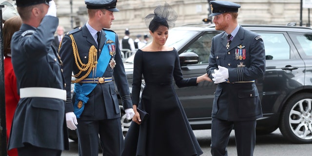 Meghan, the Duchess of Sussex, walks in with Prince Harry and Prince William as they arrive for a service at Westminster Abbey to mark the centenary of the Royal Air Force.