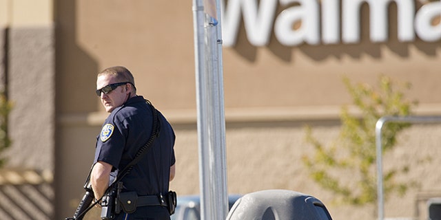 Oct. 29: Reno police officers search through trash cans in the parking lot during a standoff following a shooting at a Reno Walmart.
