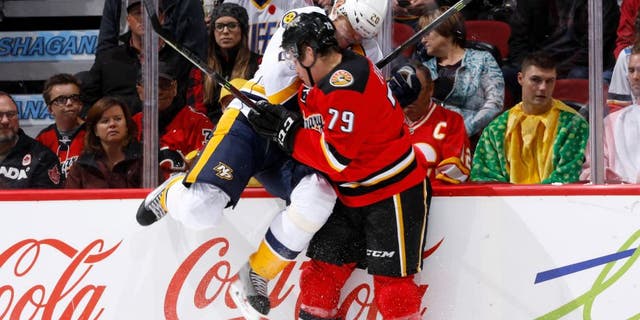 CALGARY, AB - OCTOBER 31: Michael Ferland #79 of the Calgary Flames checks Anton Volchenkov #20 of the Nashville Predators into the boards at Scotiabank Saddledome on October 31, 2014 in Calgary, Alberta, Canada. (Photo by Gerry Thomas/NHLI via Getty Images)