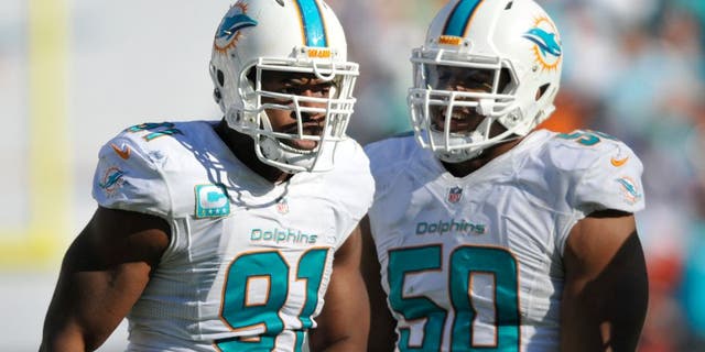 Nov 2, 2014; Miami Gardens, FL, USA; Miami Dolphins defensive tackle Earl Mitchell (90) celebrates with Miami Dolphins defensive end Olivier Vernon (50) after a sack against the San Diego Chargers at Sun Life Stadium. Miami defeated the Chargers 37-0. Mandatory Credit: Brad Barr-USA TODAY Sports