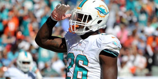 Nov 2, 2014; Miami Gardens, FL, USA; Miami Dolphins running back Lamar Miller (26) celebrates after scoring a touchdown against the San Diego Chargers during the first half at Sun Life Stadium. Mandatory Credit: Steve Mitchell-USA TODAY Sports