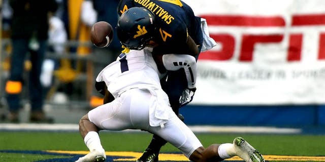 Nov 1, 2014; Morgantown, WV, USA; TCU Horned Frogs safety Chris Hackett (1) forces West Virginia Mountaineers running back Wendell Smallwood (4) to fumble during the second quarter at Milan Puskar Stadium. Mandatory Credit: Tommy Gilligan-USA TODAY Sports