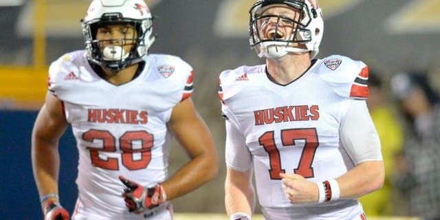 Northern Illinois quarterback Ryan Graham (17) and running back Joel Bouagnon (28) celebrate after Bouagnon's 2-yard rushing touchdown during the fourth quarter of an NCAA college football game against Toledo on Tuesday, Nov. 3, 2015, in Toledo, Ohio. Northern Illinois won 32-27. (AP Photo/David Richard)