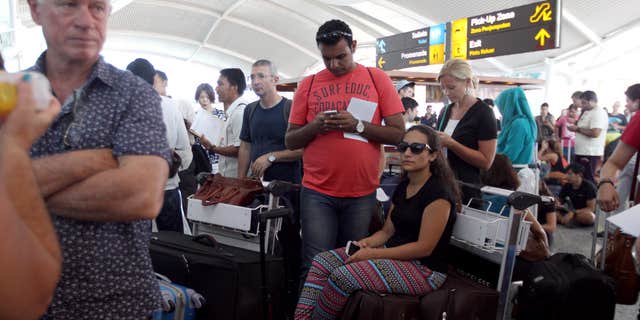 Nov. 4, 2015: Passengers wait to check the status of their flights with airline desk at Ngurah Rai International Airport in Bali, Indonesia.