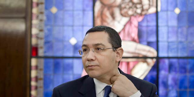 June 9, 2015: Romanian Prime Minister, Victor Ponta, adjusts his collar during a meeting with foreign media at the government headquarters in Bucharest.