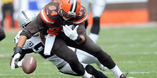 Sep 27, 2015; Cleveland, OH, USA; Cleveland Browns tight end Rob Housler (84) has a the ball stripped by Oakland Raiders free safety Charles Woodson (24) during the first half at FirstEnergy Stadium. Mandatory Credit: Ken Blaze-USA TODAY Sports