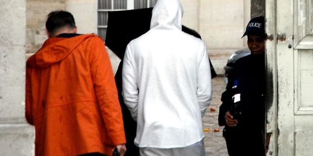 French footballer Karim Benzema (C), wearing a white hooded jersey, arrives at the police station in Versailles, southwest of Paris, on November 4, 2015. French footballer Karim Benzema was arrested on November 4 in connection with blackmail over a sextape featuring fellow player Mathieu Valbuena, a source close to the probe told AFP. AFP PHOTO / MATTHIEU ALEXANDRE (Photo credit should read MATTHIEU ALEXANDRE/AFP/Getty Images)