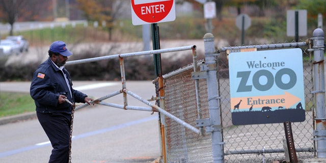 Nov. 4, 2012: A security guard closes the gate at the Pittsburgh Zoo, where zoo officials say a young boy was killed after he fell into the exhibit that was home to a pack of African painted dogs.