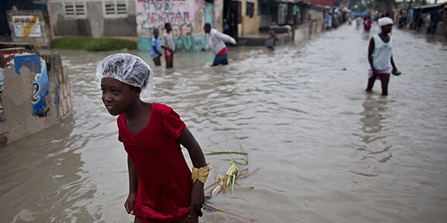 Nov. 6: People walk in a flooded street after the passing of Hurricane Tomas in the neighborhood of Cite Soleil in Port-au-Prince, Haiti.