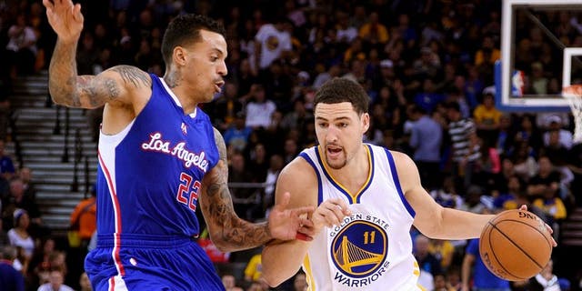 November 5, 2014; Oakland, CA, USA; Golden State Warriors guard Klay Thompson (11) dribbles the basketball against Los Angeles Clippers forward Matt Barnes (22) during the third quarter at Oracle Arena. The Warriors defeated the Clippers 121-104. Mandatory Credit: Kyle Terada-USA TODAY Sports