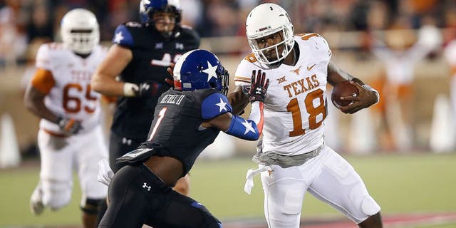 Texas' Tyrone Swoopes runs against Texas Tech's Nigel Bethel II during an NCAA college football game in Lubbock, Texas, Saturday, Nov. 1, 2014. (AP Photo/Lubbock Avalanche-Journal, Tori Eichberger)