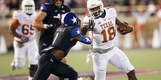 Texas' Tyrone Swoopes runs against Texas Tech's Nigel Bethel II during an NCAA college football game in Lubbock, Texas, Saturday, Nov. 1, 2014. (AP Photo/Lubbock Avalanche-Journal, Tori Eichberger)
