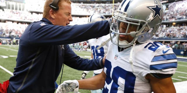 Dallas Cowboys head coach Jason Garrett congratulates defensive back Tyler Patmon (20) after interception and run back for a touchdown during the first half of an NFL football game against the Arizona Cardinals Tuesday, Feb. 11, 2014, in Arlington, Texas. (AP Photo/Brandon Wade)