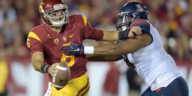Nov 7, 2015; Los Angeles, CA, USA; Southern California Trojans quarterback Cody Kessler (6) is pressured by Arizona Wildcats defensive end Reggie Gilbert (8) at Los Angeles Memorial Coliseum. Mandatory Credit: Kirby Lee-USA TODAY Sports