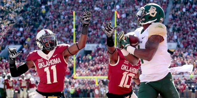 NORMAN, OK - NOVEMBER 8: Running back Corey Coleman #1 of the Baylor Bears catches a touchdown pass as safety Steven Parker #11 and safety Quentin Hayes #10 of the Oklahoma Sooners defends November 8, 2014 at Gaylord Family-Oklahoma Memorial Stadium in Norman, Oklahoma. (Photo by Brett Deering/Getty Images)