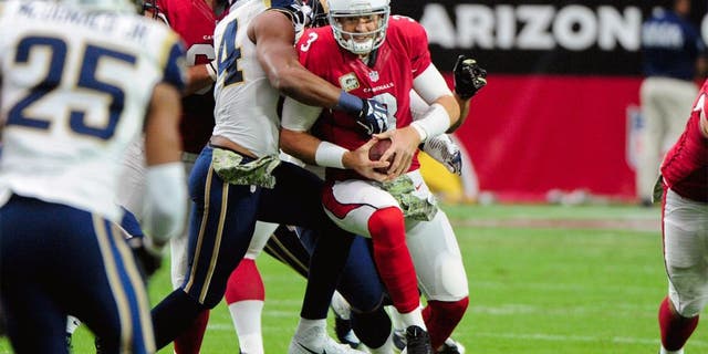 Nov 9, 2014; Glendale, AZ, USA; Arizona Cardinals quarterback Carson Palmer (3) is sacked by St. Louis Rams defensive end Robert Quinn (94) and defensive tackle Aaron Donald (99) during the first half at University of Phoenix Stadium. Mandatory Credit: Matt Kartozian-USA TODAY Sports