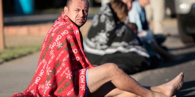Nov. 10: Mark Rodriguez-Banks sits on the ground during a raid in Phoenix.