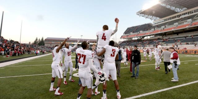 Nov 8, 2014; Corvallis, OR, USA; Washington State Cougars quarterback Luke Falk (4) is lifted into the air by linebacker Ivan McLennan (3) and wide receiver Rickey Galvin (5) following a win against the Oregon State Beavers against the Oregon State Beavers at Reser Stadium. Mandatory Credit: Scott Olmos-USA TODAY Sports