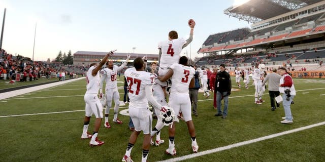 Nov 8, 2014; Corvallis, OR, USA; Washington State Cougars quarterback Luke Falk (4) is lifted into the air by linebacker Ivan McLennan (3) and wide receiver Rickey Galvin (5) following a win against the Oregon State Beavers against the Oregon State Beavers at Reser Stadium. Mandatory Credit: Scott Olmos-USA TODAY Sports