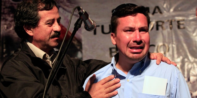 Oct. 19: Rescued miner Edison Pena, right, cries while fellow rescued miner Juan Illanes supports him during a ceremony honoring the miners in Caldera, Chile.