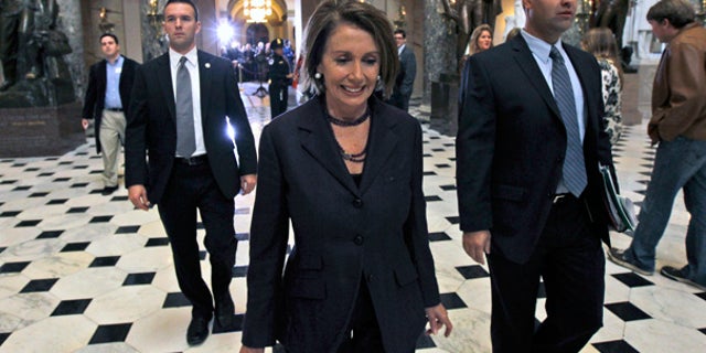 Nov. 10: House Speaker Nancy Pelosi walks past the set up for a news conference for House Speaker-in-waiting John Boehner.