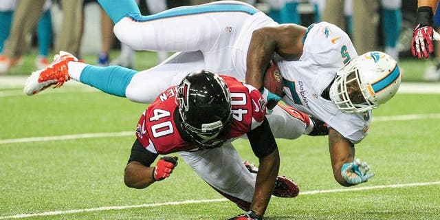 ATLANTA, GA - AUGUST 08: Damien Williams #5 of the Miami Dolphins is tackled by Kimario McFadden #40 of the Atlanta Falcons in the fourth quarter of a preseason game at the Georgia Dome on August 8, 2014 in Atlanta, Georgia. The Falcons won 16-10. (Photo by Scott Cunningham/Getty Images)