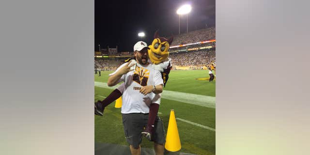 Sept. 18, 2015L This photo courtesy of David Schapira shows ASU’s mascot Sparky jumping on David Schapira at a Arizona State University football game in Tempe, Ariz.
