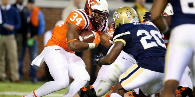 Nov 12, 2015; Atlanta, GA, USA; Virginia Tech Hokies running back Travon McMillian (34) runs against Georgia Tech Yellow Jackets defensive back Lawrence Austin (20) in the second quarter of their game at Bobby Dodd Stadium. Mandatory Credit: Jason Getz-USA TODAY Sports