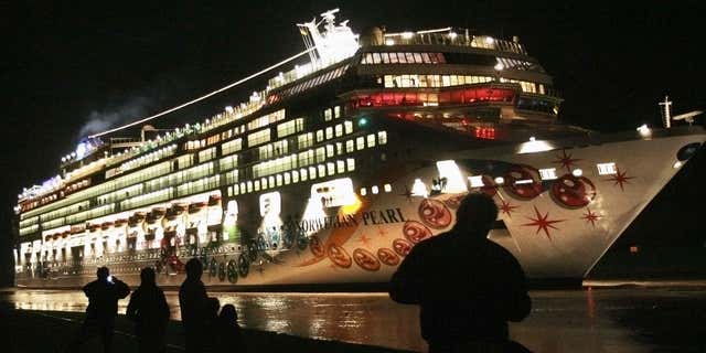 Nov. 7, 2006: People stand on a dyke watching the newly built cruise ship 'Norwegian Pearl' on its passage from the Meyer shipyard in Papenburg to the North Sea.