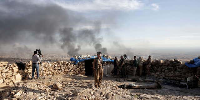 Nov. 12, 2015: Smoke rises over Sinjar, northern Iraq from oil fires set by Islamic State militants as Kurdish Iraqi fighters, backed by U.S.-led airstrikes, launch a major assault.